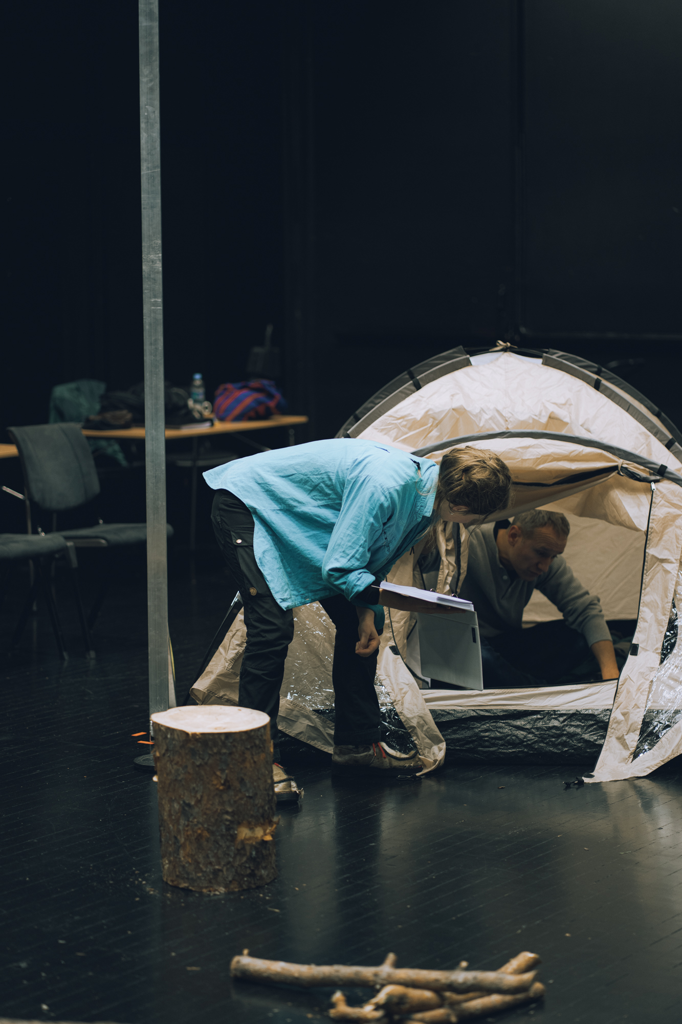 En mann i et telt, ei dame foran kikker inn