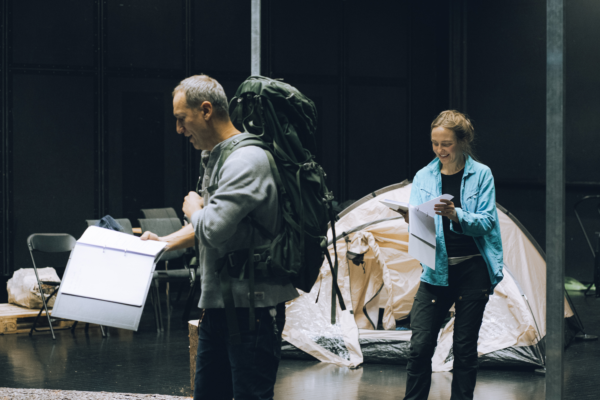 Leseprøver mann med sekk og dame foran telt