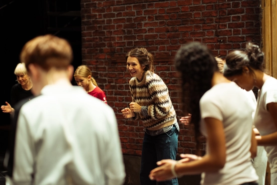 Katrine Strøm på scenen sammen med barn som leker konsentrert